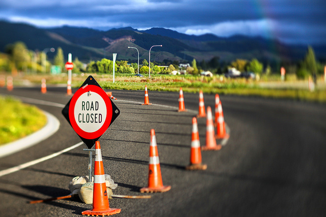 Image of orange construction cones on a curved road