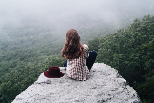 Image of woman sitting on a mountaintop
