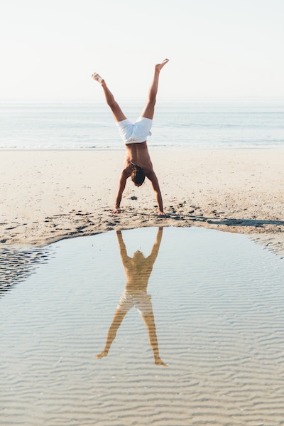 Image of a man doing a handstand on the beach