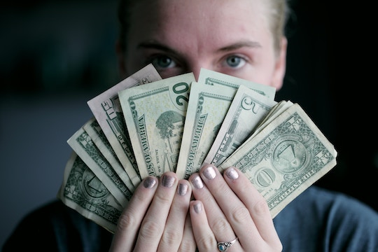 Image of a woman holding a fan of American money