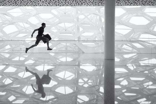 Image of a man running across a glass floor