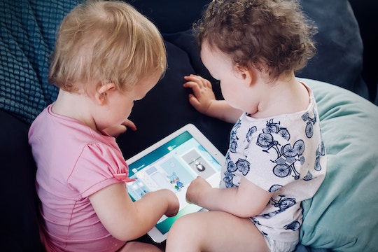 Image of two toddlers playing with a computer