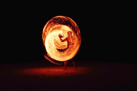 Image of a man spiraling a wand of fire