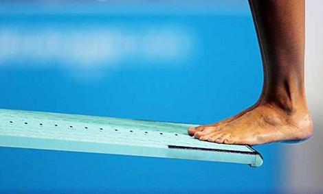 Image of a man standing on the end of a diving board