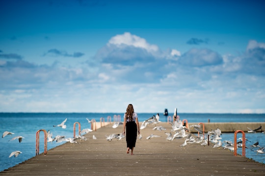 Image of a woman walking among birds