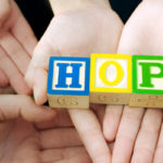 Hands holding letters spelling "HOPE"