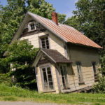Image of an old house crooked on its foundation