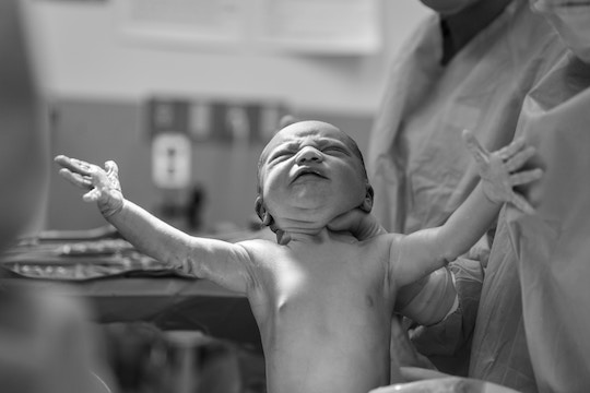 Image of a physician holding a newborn