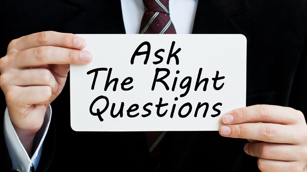 Image of man holding placard saying "Ask the right questions"