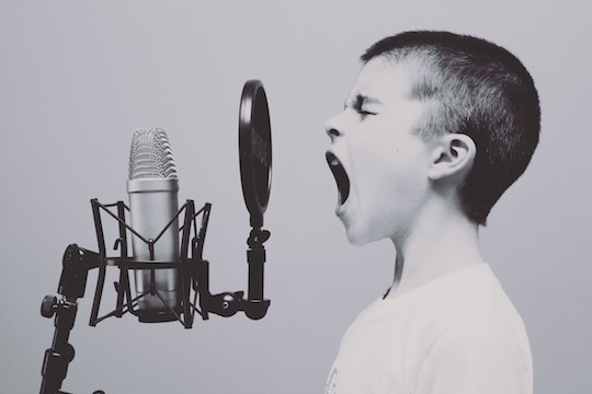 Image of a boy screaming into a microphone