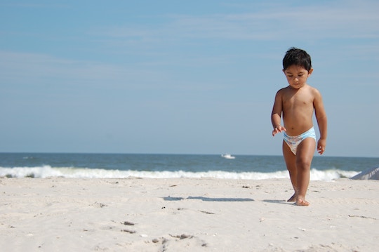 Image of a small boy walking on the beach