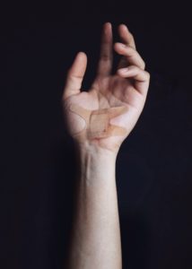 Image of a hand with a large bandaid on the palm