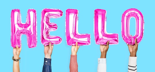 Image of hands holding up pink balloons spelling "hello"