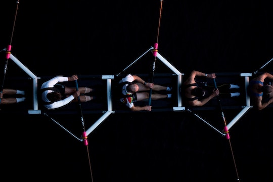 Image of men rowing against a black background