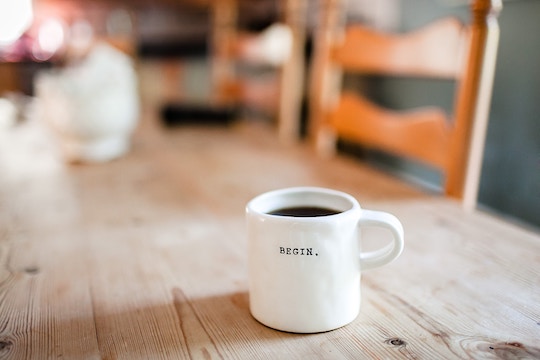 Image of a white coffee cup inscribed "begin"